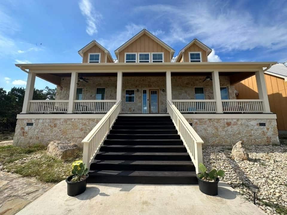 Two-story stone and Hardie board-and-batten exterior painting project on Pace Bend Road South in Spicewood, TX, completed by Fresh Coat Painters of Marble Falls. ÿþ2