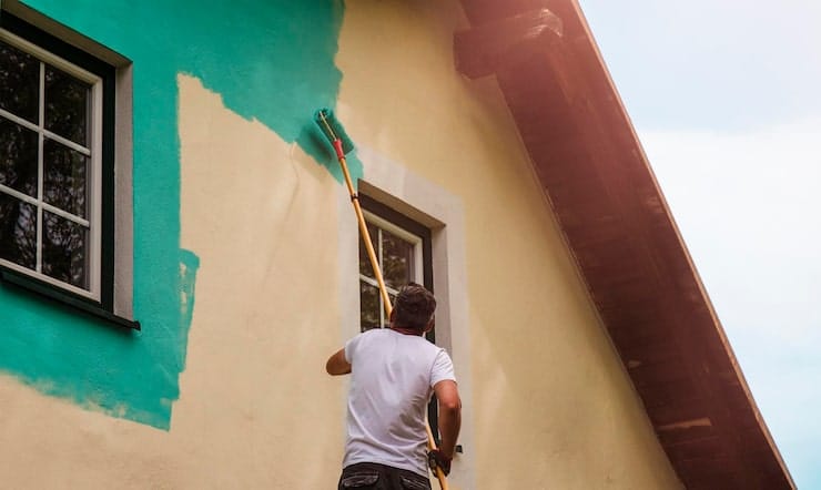 worker-paints-facade-walls-house